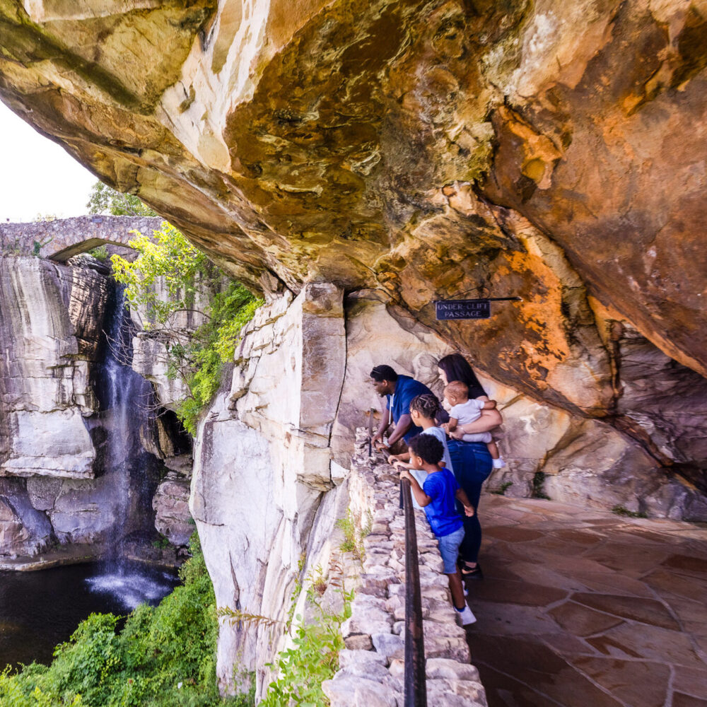 Family experiencing stunning views from Under-Cliff Passage on the kid-friendly hiking trails at Rock City on Lookout Mountain.