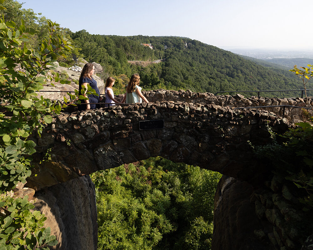 Family walking over stone bridge at Rock City.