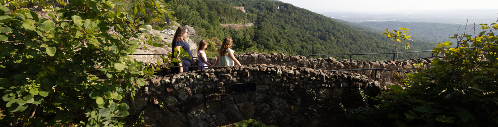 Family walking over stone bridge at Rock City.