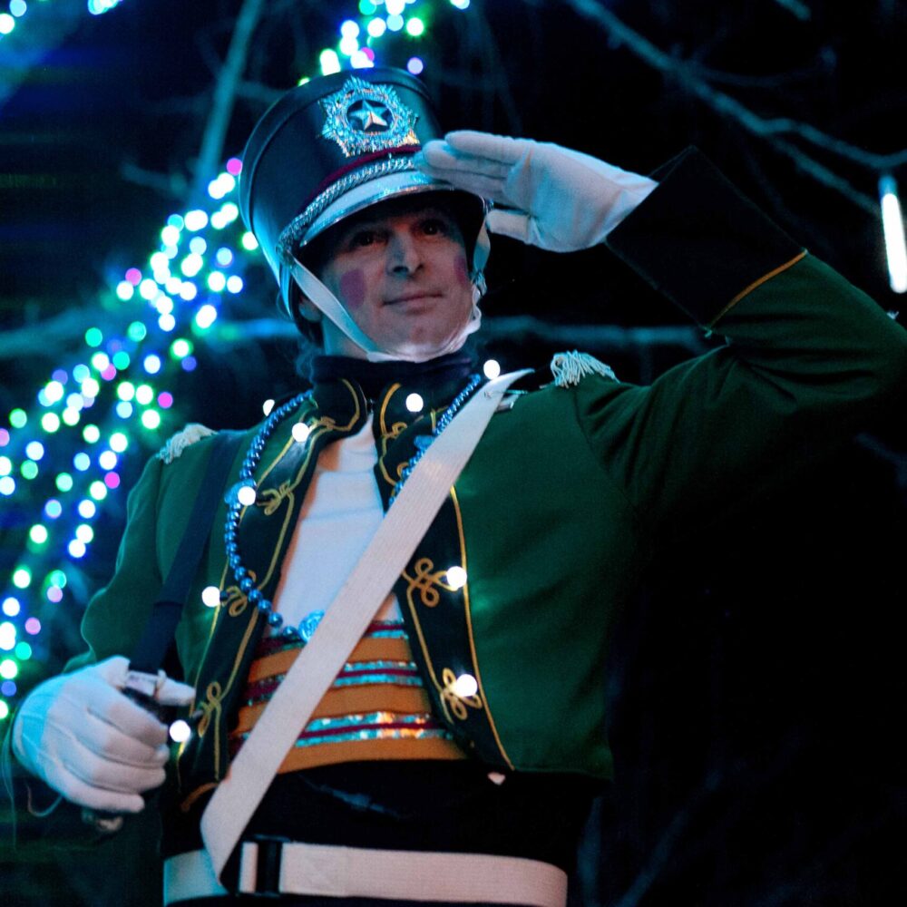 Actor dressed as toy soldier posing in a salute.